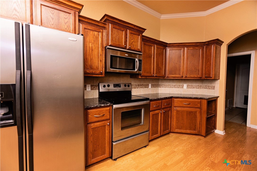 115 Squire Loop Belton, TX 76513 - Photo 16 of 38 a kitchen with stainless steel appliances granite countertop a refrigerator stove and sink