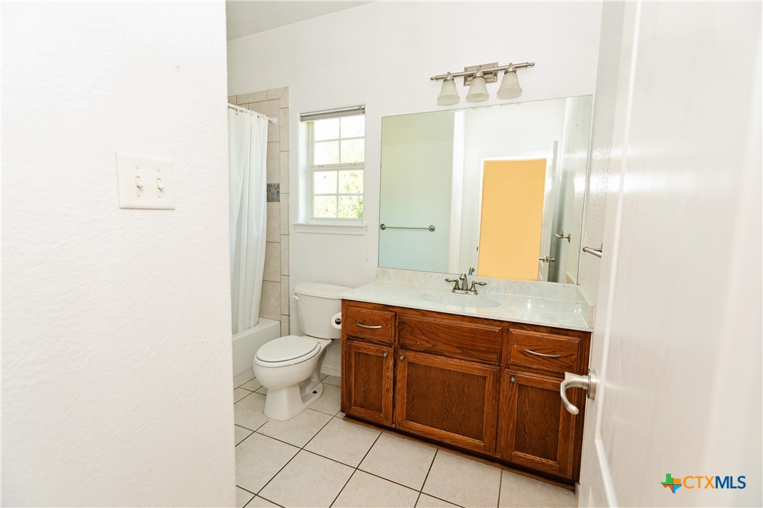 115 Squire Loop Belton, TX 76513 - Photo 23 of 38 a bathroom with a granite countertop toilet sink and mirror