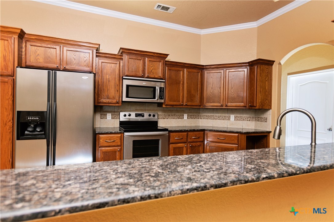 115 Squire Loop Belton, TX 76513 - Photo 28 of 38 a kitchen with granite countertop a refrigerator stove and sink