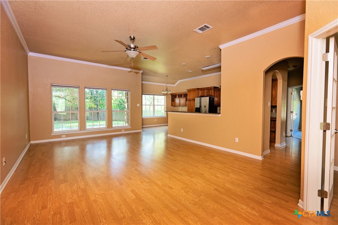115 Squire Loop Belton, TX 76513 - Photo 9 of 38 a view of a livingroom with wooden floor a ceiling fan and windows
