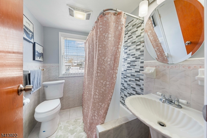 828 Allen Street Linden, NJ 07036 - Photo 14 of 18 a bathroom with a toilet sink and mirror