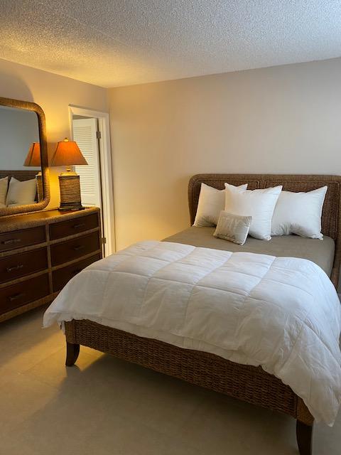 312 Southwind Drive, Unit 102 North Palm Beach, FL 33408 - Photo 8 of 18 a bedroom with a bed and dresser