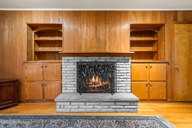 a living room with a fireplace and cabinets