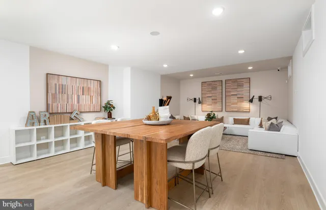 a dining room with wooden floor a chandelier a wooden table and chairs