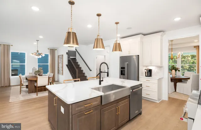 a kitchen with stainless steel appliances kitchen island granite countertop a refrigerator and a stove top oven