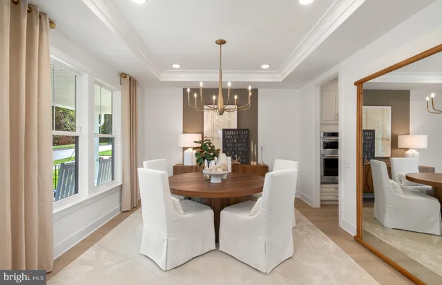 a dining room with furniture a chandelier and wooden floor