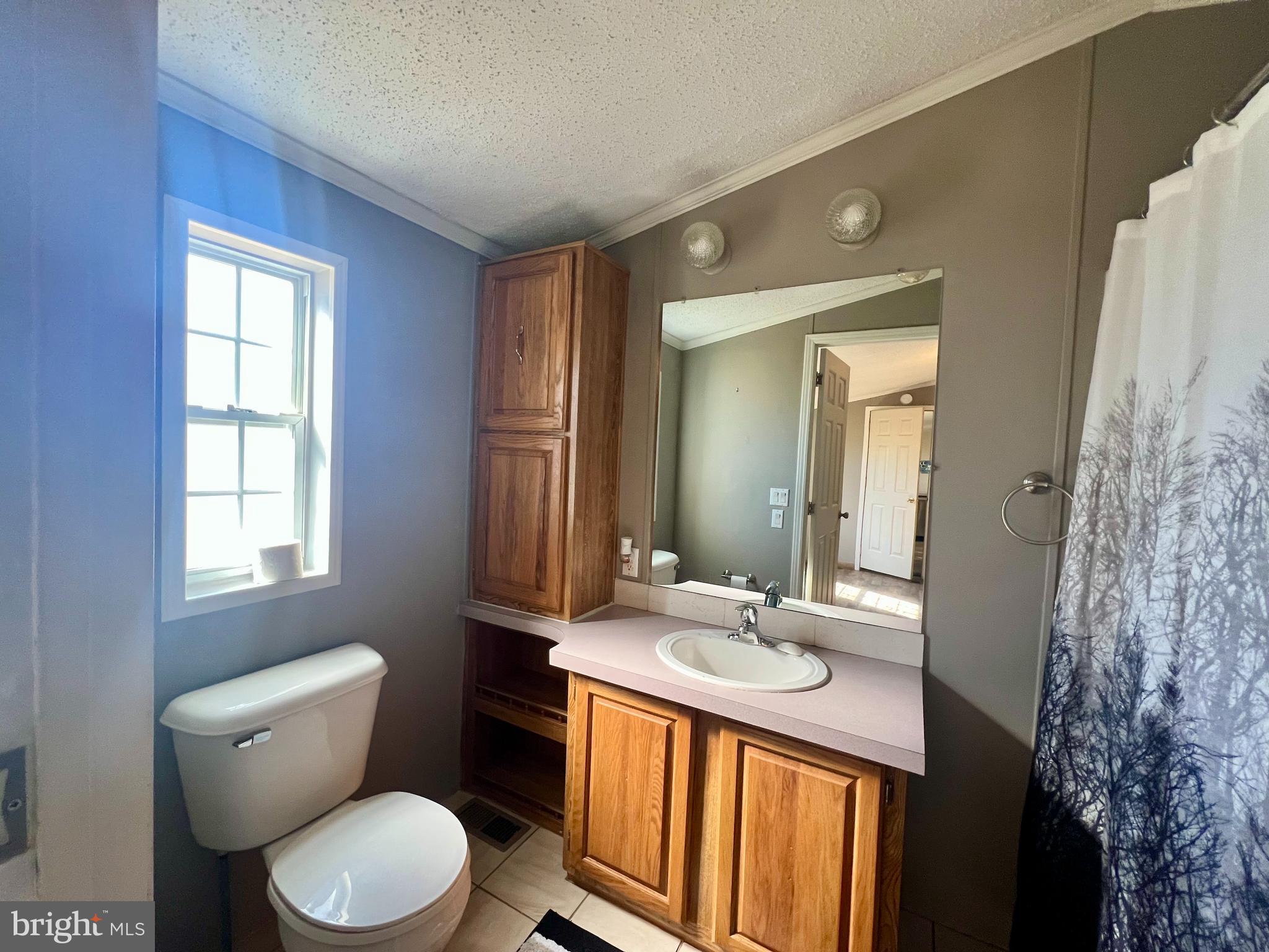 768 East Garden Road, Unit 14 Vineland, NJ 08360 - Photo 15 of 33 a bathroom with a granite countertop toilet sink and mirror