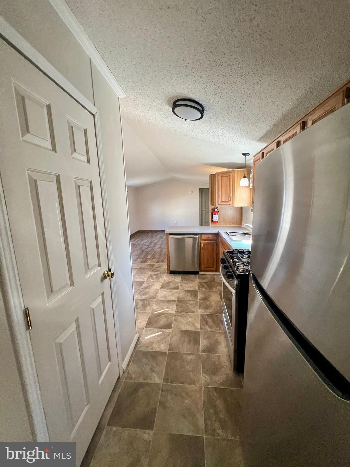 768 East Garden Road, Unit 14 Vineland, NJ 08360 - Photo 18 of 33 a view of a hallway to a livingroom with wooden floor and furniture