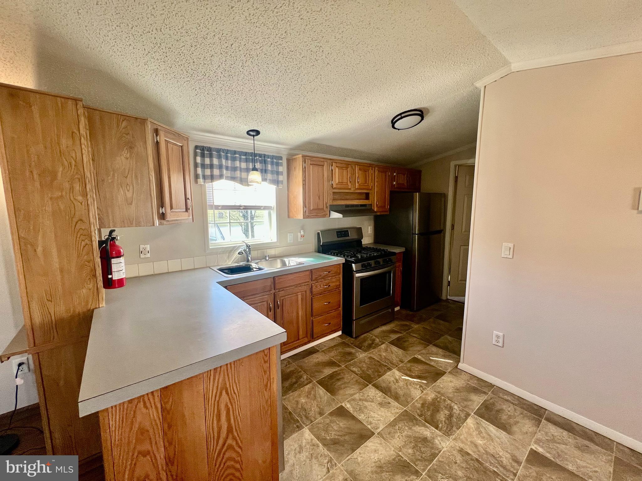 768 East Garden Road, Unit 14 Vineland, NJ 08360 - Photo 8 of 33 a kitchen with stainless steel appliances granite countertop a stove a sink and a refrigerator