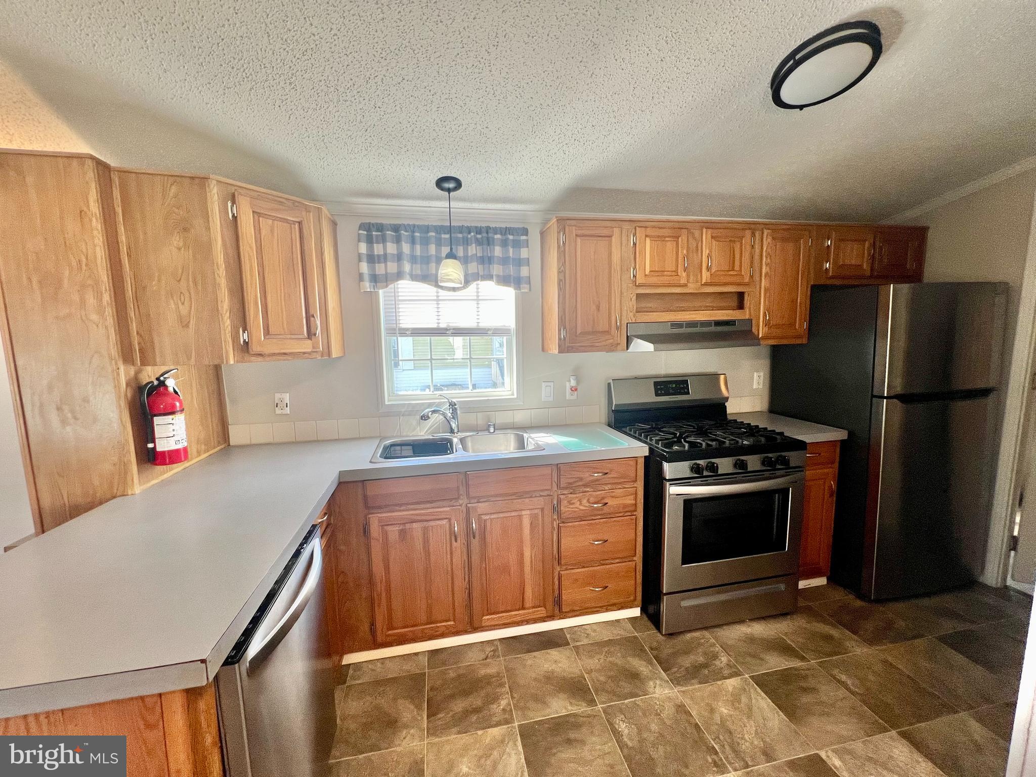 768 East Garden Road, Unit 14 Vineland, NJ 08360 - Photo 9 of 33 a kitchen with stainless steel appliances granite countertop a stove a sink dishwasher a refrigerator and a microwave