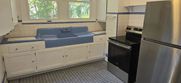 a kitchen with white cabinets and black appliances