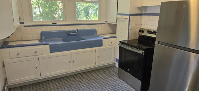 a kitchen with white cabinets and black appliances