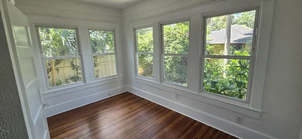 a view of empty room with wooden floor and fan