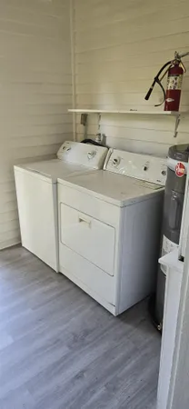 a utility room with wooden floor washer and dryer