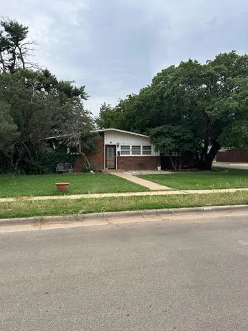a view of a house with a big yard and large trees