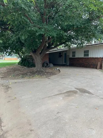 a view of a car in front of a small yard