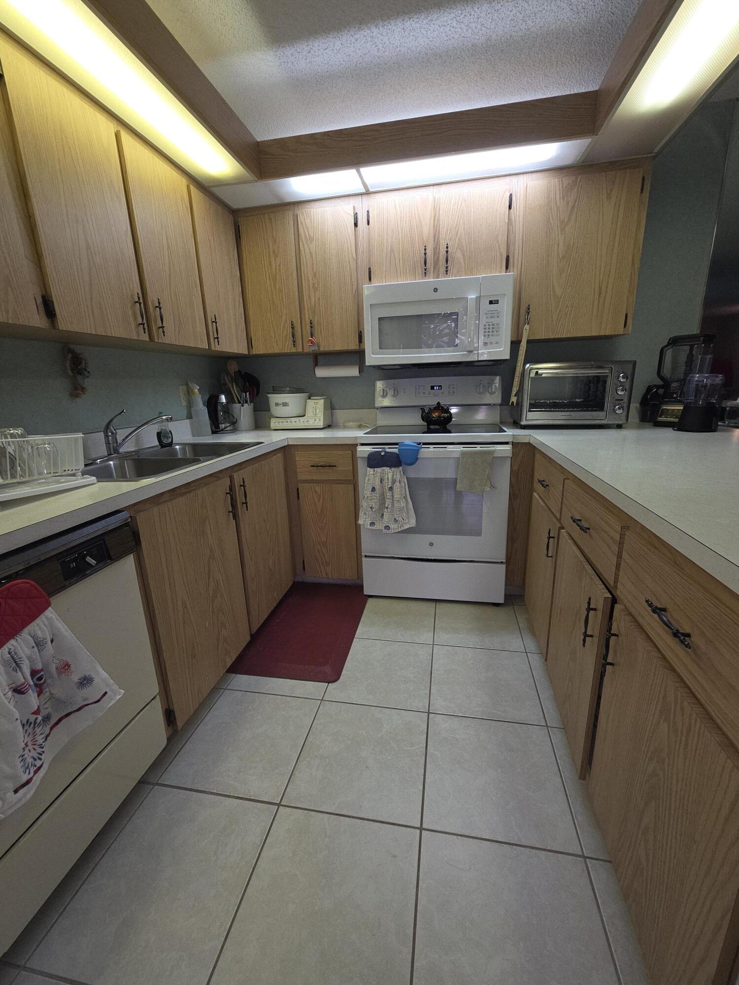 1170 6th Avenue, Unit 3A Vero Beach, FL 32960 - Photo 12 of 31 a kitchen with a sink a stove and cabinets
