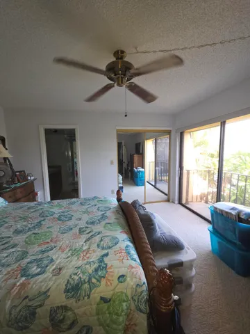a bed sitting in a spacious bedroom next to a window