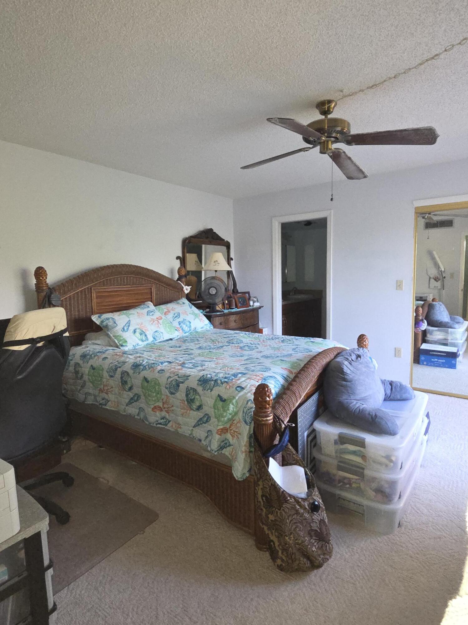 1170 6th Avenue, Unit 3A Vero Beach, FL 32960 - Photo 17 of 31 a bedroom with a bed and a chandelier