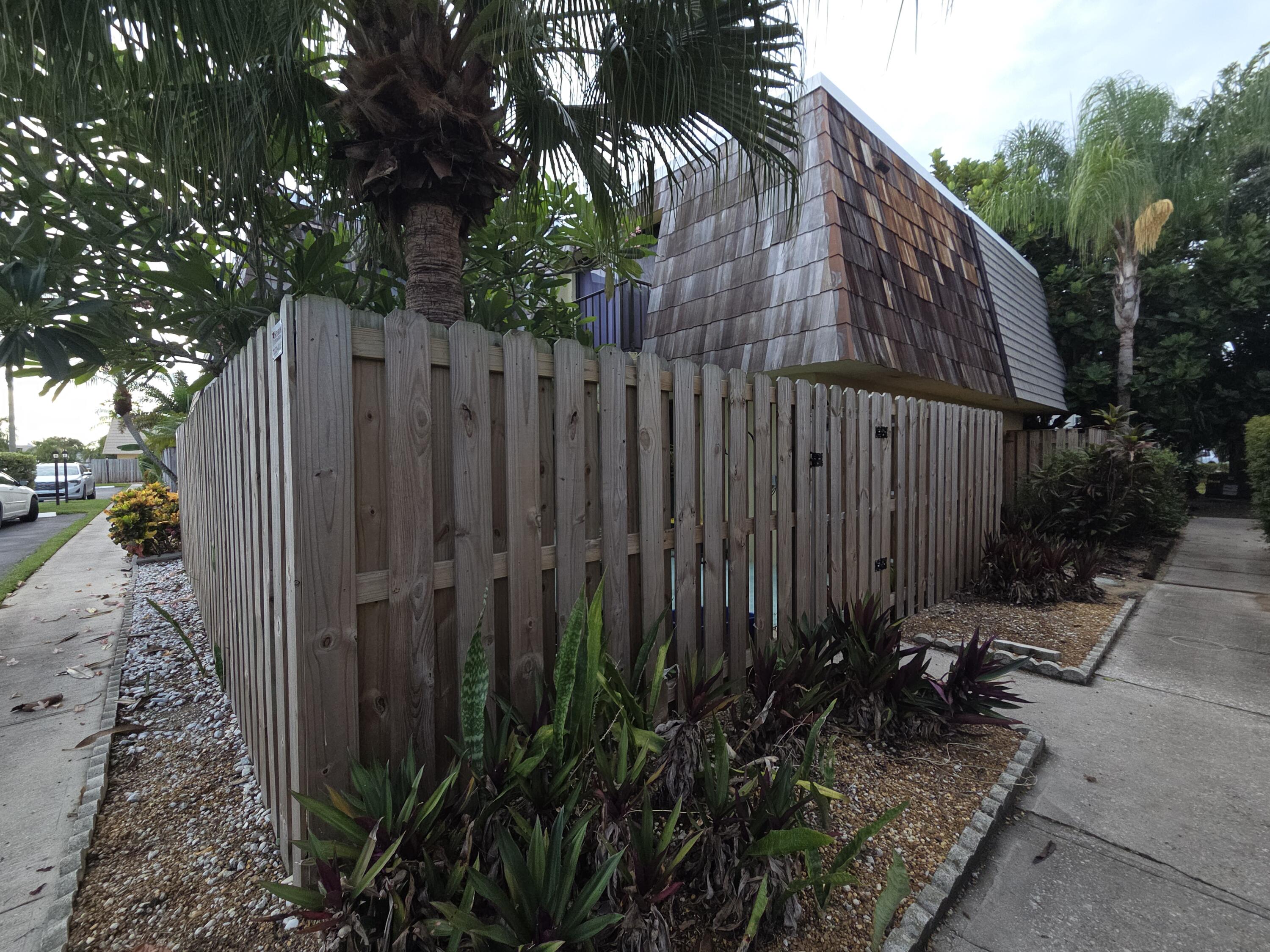 1170 6th Avenue, Unit 3A Vero Beach, FL 32960 - Photo 3 of 31 a view of a backyard with potted plants and wooden fence