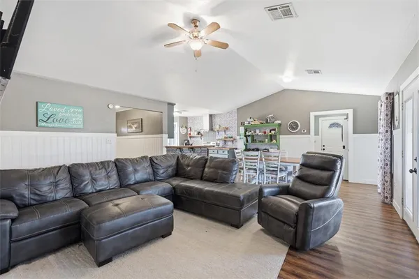 a living room with furniture and a wooden floor