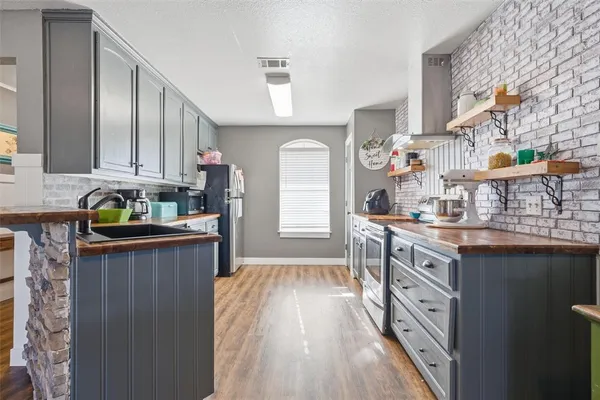 a kitchen with granite countertop a sink stove and cabinets