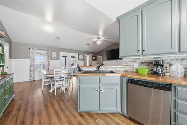 a kitchen with a sink cabinets and wooden floor