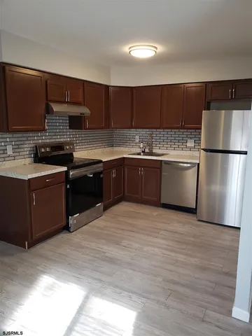 a kitchen with stainless steel appliances granite countertop a refrigerator and a stove top oven