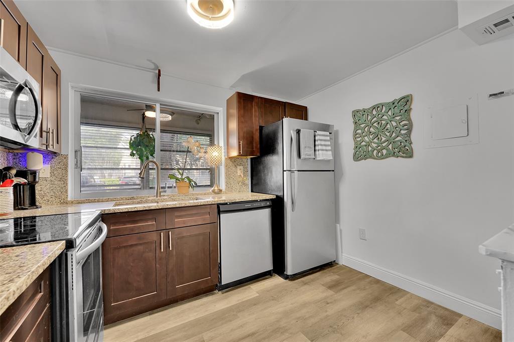 9090 Lime Bay Boulevard, Unit 112 Tamarac, FL 33321 - Photo 11 of 55 a kitchen with stainless steel appliances granite countertop a refrigerator and a sink
