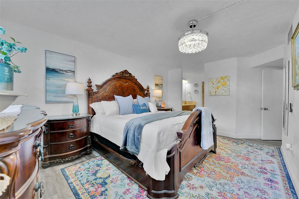 9090 Lime Bay Boulevard, Unit 112 Tamarac, FL 33321 - Photo 22 of 55 a bed room with a bed and a chandelier