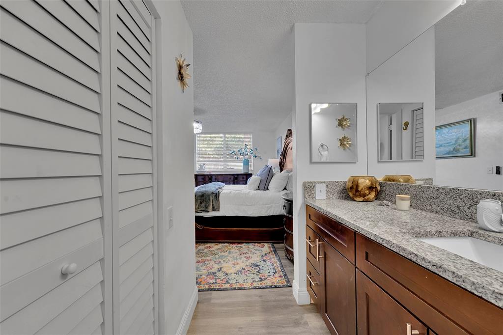 9090 Lime Bay Boulevard, Unit 112 Tamarac, FL 33321 - Photo 27 of 55 a bedroom with a bed and a walk in closet