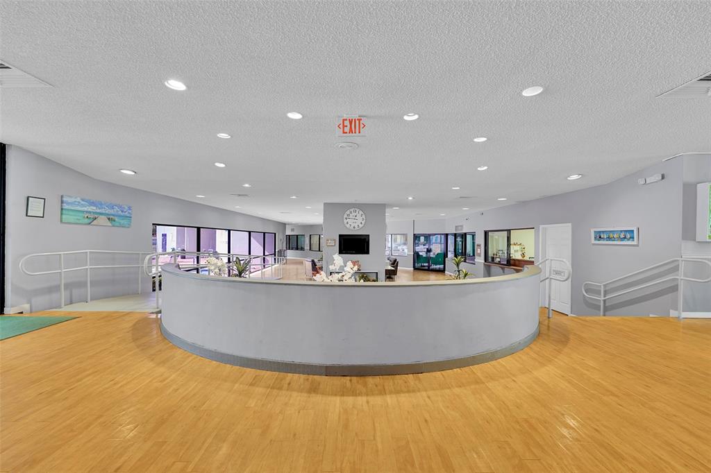 9090 Lime Bay Boulevard, Unit 112 Tamarac, FL 33321 - Photo 28 of 55 a living room with kitchen furniture and a wooden floor