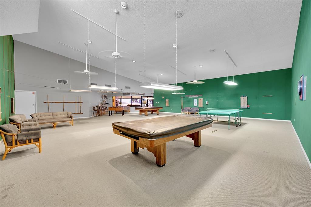 9090 Lime Bay Boulevard, Unit 112 Tamarac, FL 33321 - Photo 31 of 55 a room with lots of furniture and air hockey table