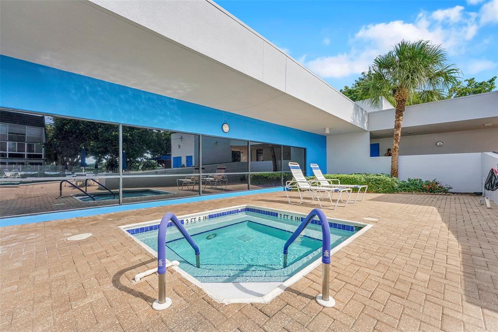 9090 Lime Bay Boulevard, Unit 112 Tamarac, FL 33321 - Photo 33 of 55 a view of swimming pool with outdoor seating and house in the background