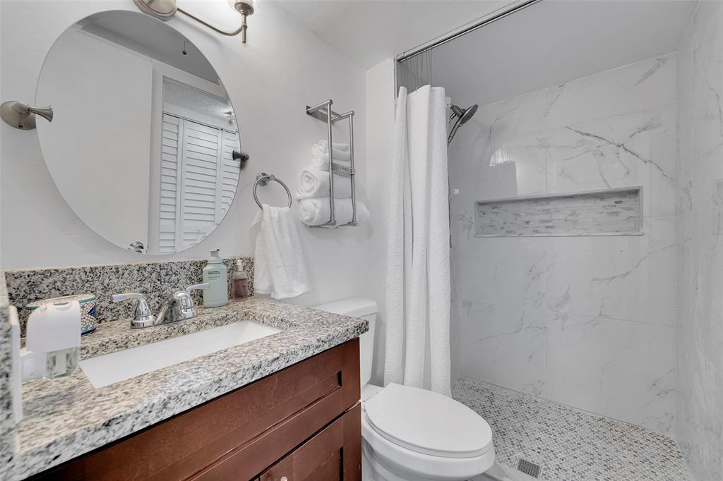 9090 Lime Bay Boulevard, Unit 112 Tamarac, FL 33321 - Photo 4 of 55 a bathroom with a granite countertop sink toilet and shower