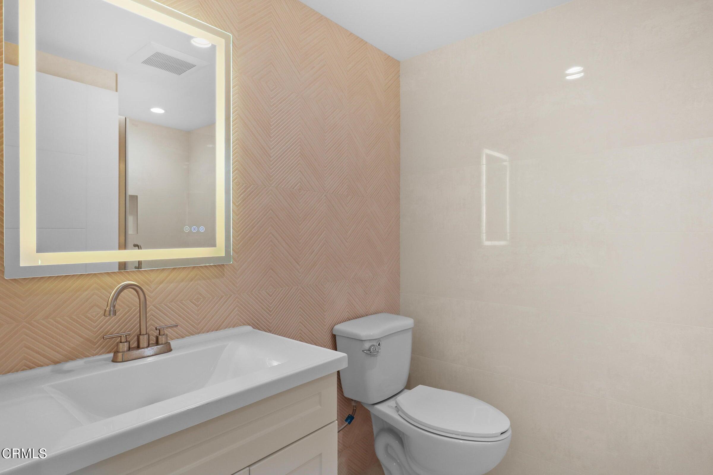 112 North Kenneth Road, Unit 101 Burbank, CA 91501 - Photo 14 of 20 a bathroom with a sink a toilet and mirror