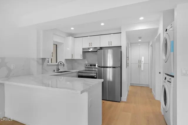 a kitchen with stainless steel appliances granite countertop a sink a stove a refrigerator and cabinets