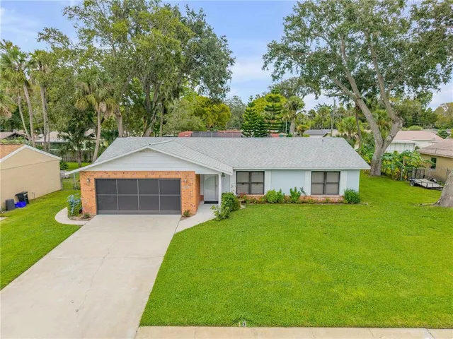 a front view of a house with yard and green space