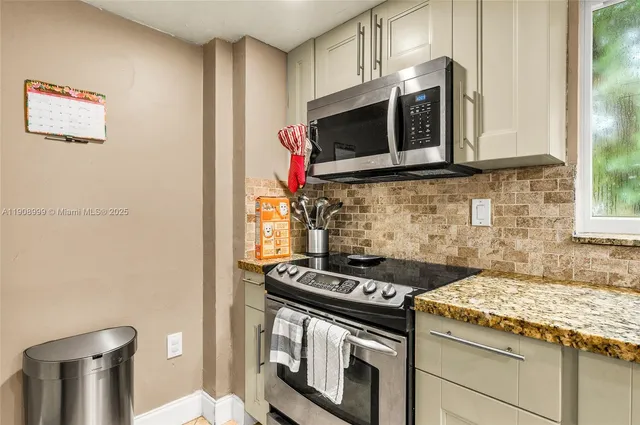 a kitchen with stainless steel appliances granite countertop a stove and a microwave