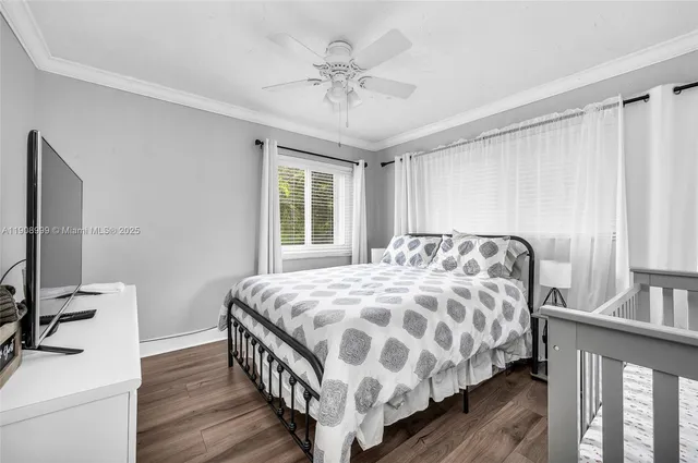 a bedroom with a bed next to a large window with wooden floor