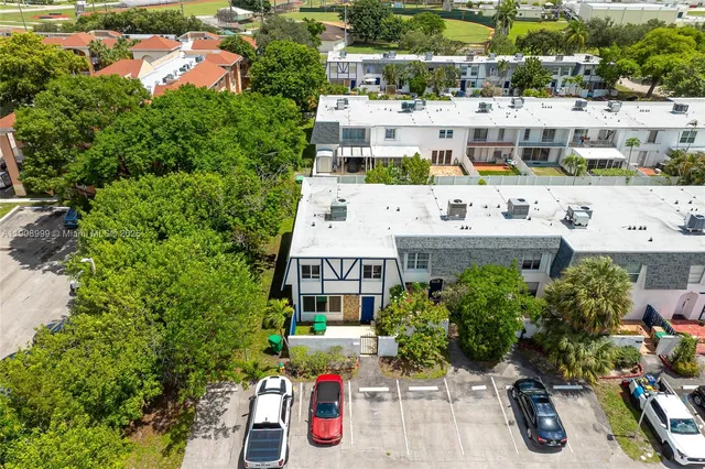 an aerial view of residential houses with yard and mountain view in back