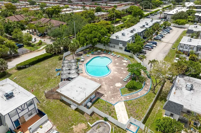 an aerial view of a house with garden space and swimming pool