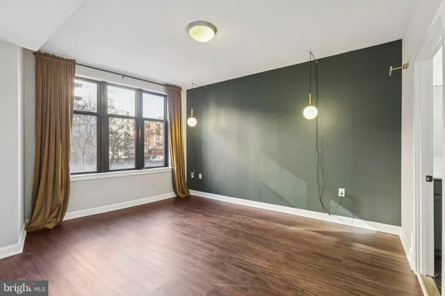 a view of an empty room with glass door and a window
