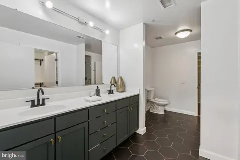 a bathroom with a double vanity sink mirror and toilet