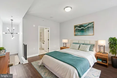 a bedroom with a bed and a wooden floor