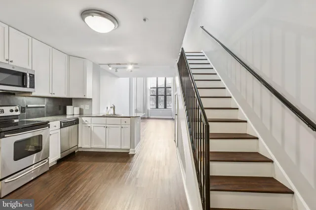 a view of a kitchen with wooden floor and electronic appliances