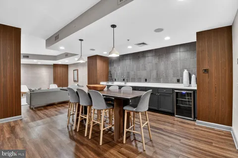 a kitchen with a dining table chairs stainless steel appliances and cabinets