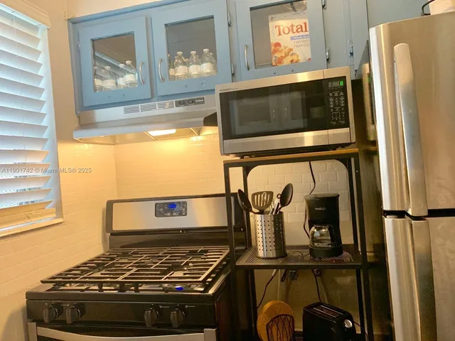 a kitchen with stainless steel appliances granite countertop a refrigerator and a stove