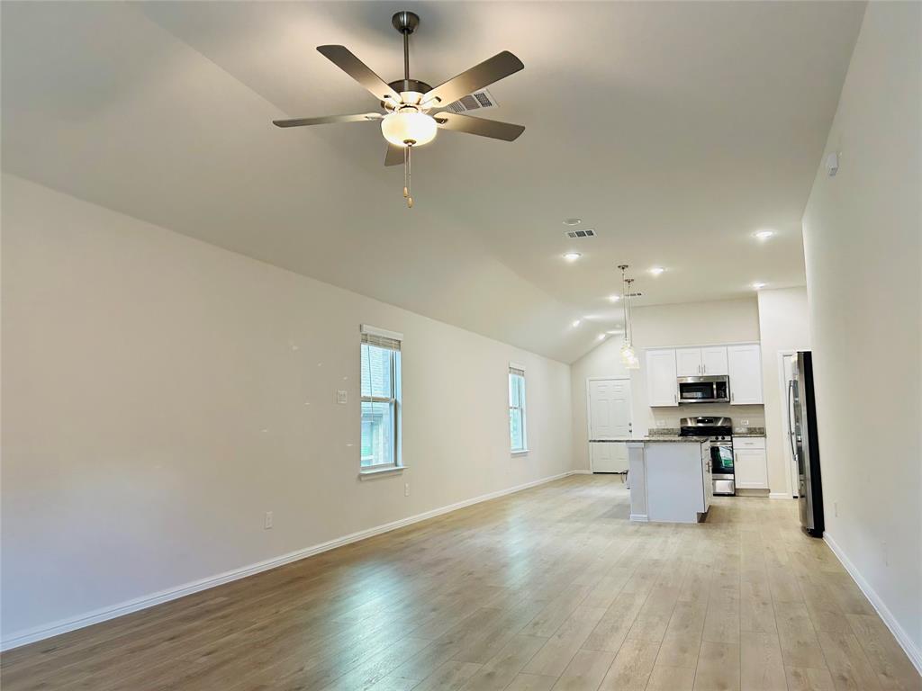 2505 McNally Drive Mesquite, TX 75181 - Photo 11 of 28 a view of a kitchen with a sink a refrigerator and a chandelier