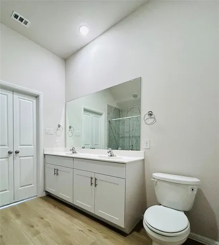 a spacious bathroom with a toilet a sink and mirror